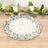 Decorative round silver platter with intricate scrollwork design.