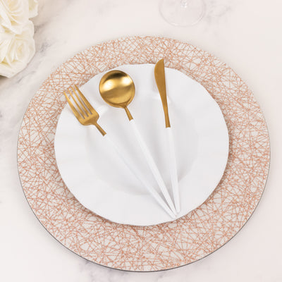 Elegant white plate with gold utensils on a stylish rose gold patterned charger.