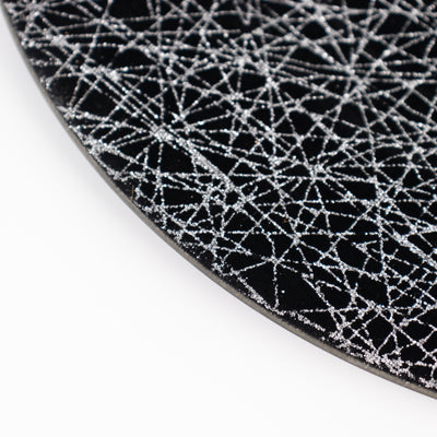 Black plate with silver abstract pattern on a white background
