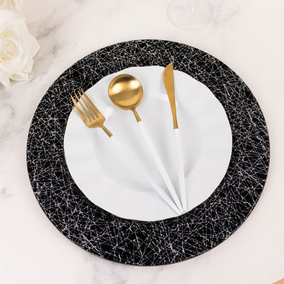 Elegant black and white dinnerware set with gold utensils on a stylish plate.
