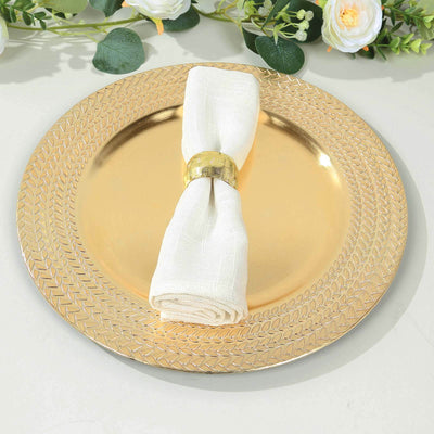 Gold decorative plate with a white napkin and gold ring on a table.