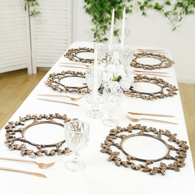 Elegant table setting with ornate gold leaf placemats and crystal glassware.