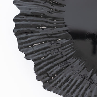 Black decorative plate with a unique ruffled edge design.