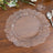 Clear decorative plate with ruffled edges on a wooden table.
