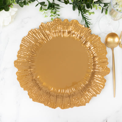 Gold decorative plate with a ruffled edge on a marble surface.