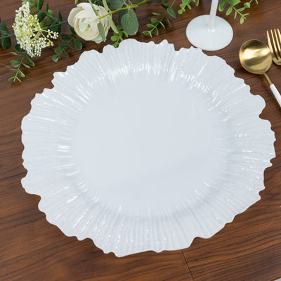 White decorative plate with a scalloped edge on a wooden table.