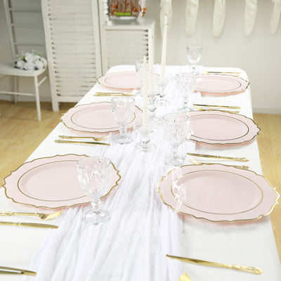 Elegant table setting with pink plates and crystal glassware.
