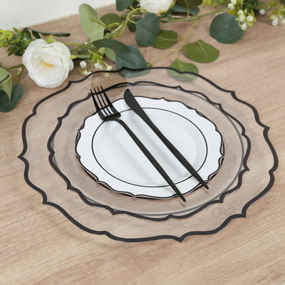 Elegant black trimmed dinnerware set with utensils on a wooden table.