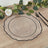 Elegant clear charger plate with black rim on a wooden table setting.
