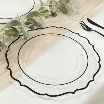 Clear plate with black scalloped rim on a table setting.