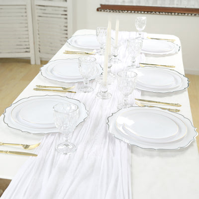 Elegant table setting with white plates, crystal glasses, and gold cutlery.