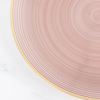 Pink textured plate with gold rim on a white background.