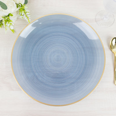 Blue decorative plate with gold rim on a light wooden table.