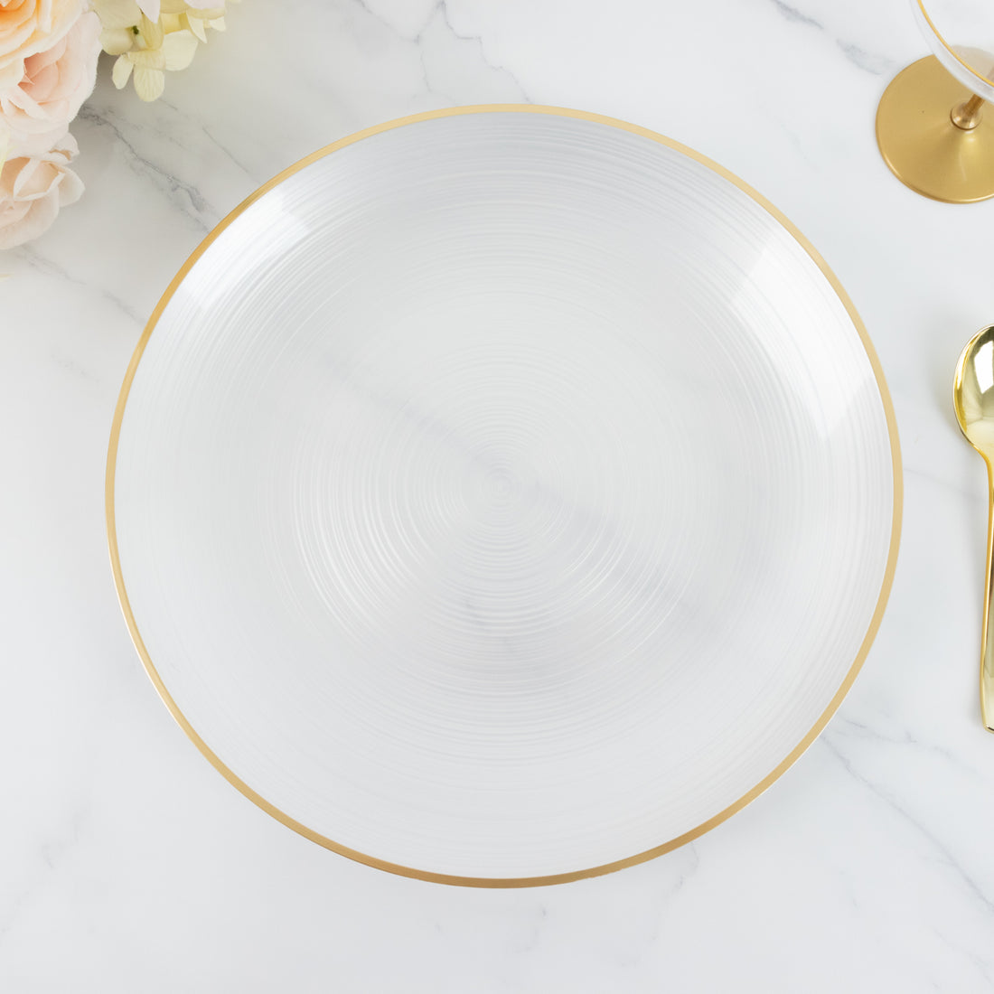 Elegant white plate with gold rim on a marble surface.