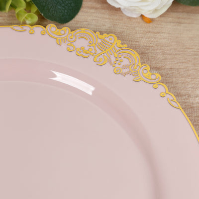 Pink plate with ornate gold trim on a wooden background.