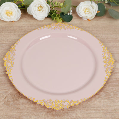 Pink decorative plate with gold trim on a wooden surface.