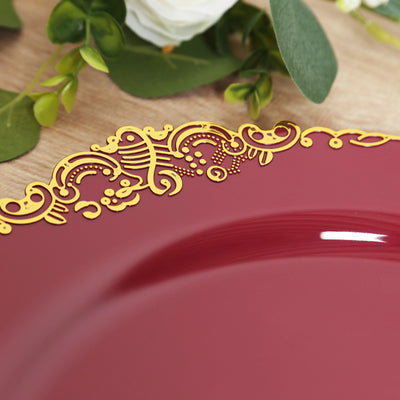 Elegant burgundy plate with intricate gold detailing on the edge.