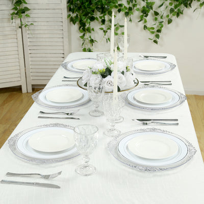 Elegant dining table set with plates, cutlery, and floral centerpiece.