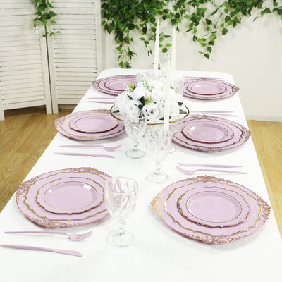 Elegant purple dinnerware set arranged on a table with floral centerpiece.