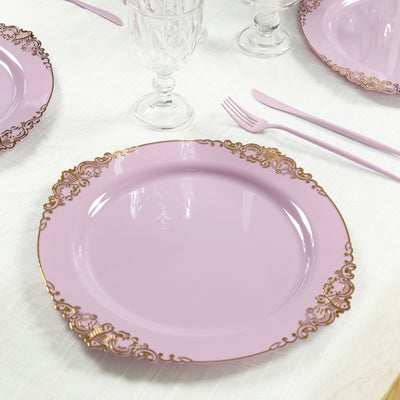 Pink decorative plate with gold trim on a textured tablecloth.