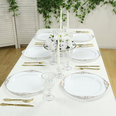Elegant dining table set with white plates, gold accents, and floral centerpiece.