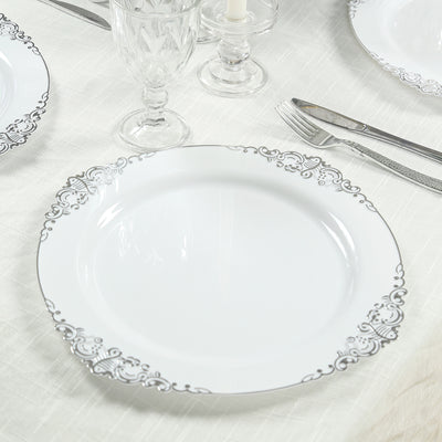 Elegant white plate with silver floral border on a table setting.