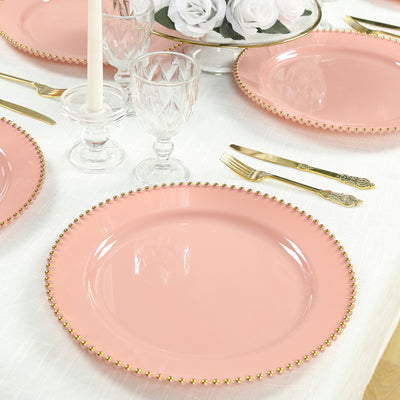 Pink dinner plate with gold beaded rim on a beautifully set dining table.