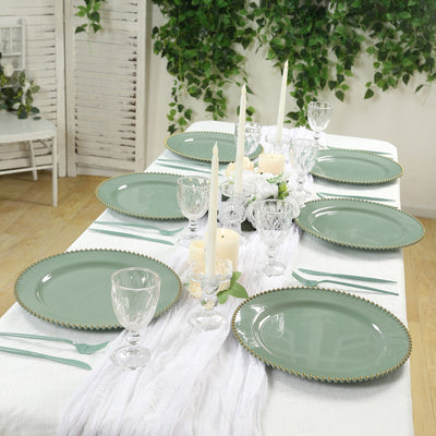 Elegant table setting with green plates, candles, and glassware in a stylish dining arrangement.