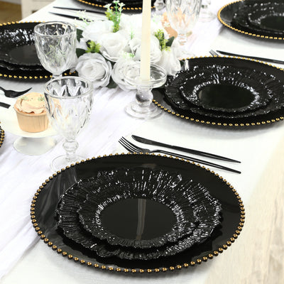 Elegant black dinner plates with textured edges and gold beads on a dining table.