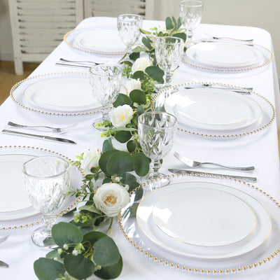 Elegant dining table set with white plates and floral centerpiece.
