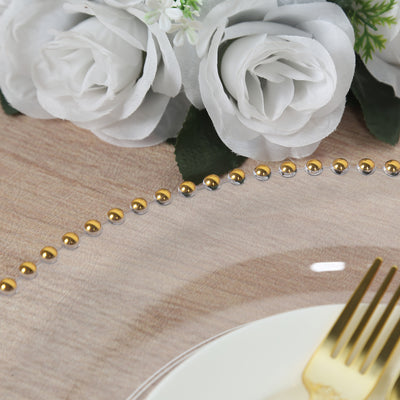 Gold and silver bead charger plate with white roses in the background.