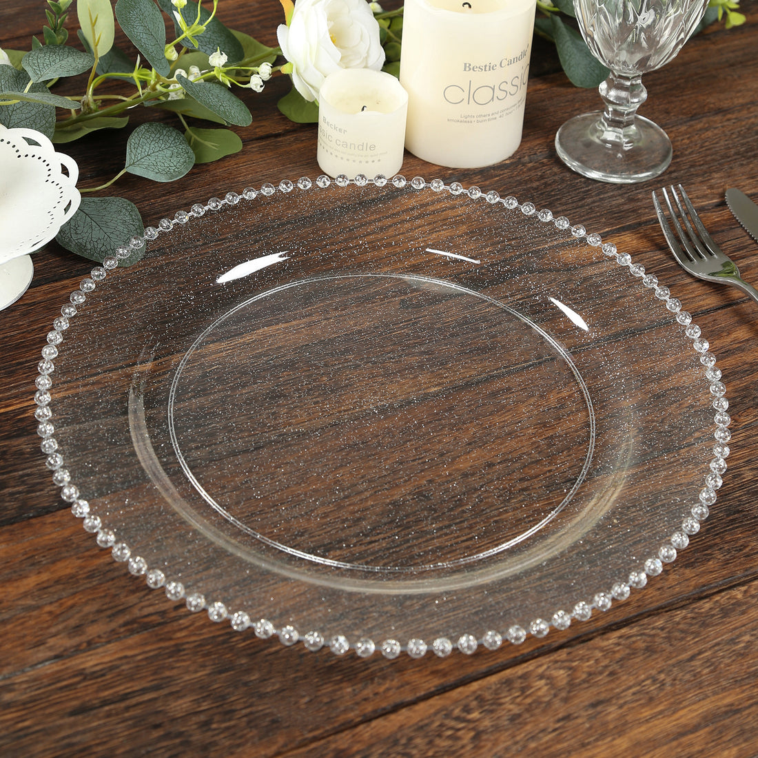 Clear decorative charger plate with beaded rim on wooden table