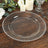 Clear decorative charger plate with beaded rim on wooden table