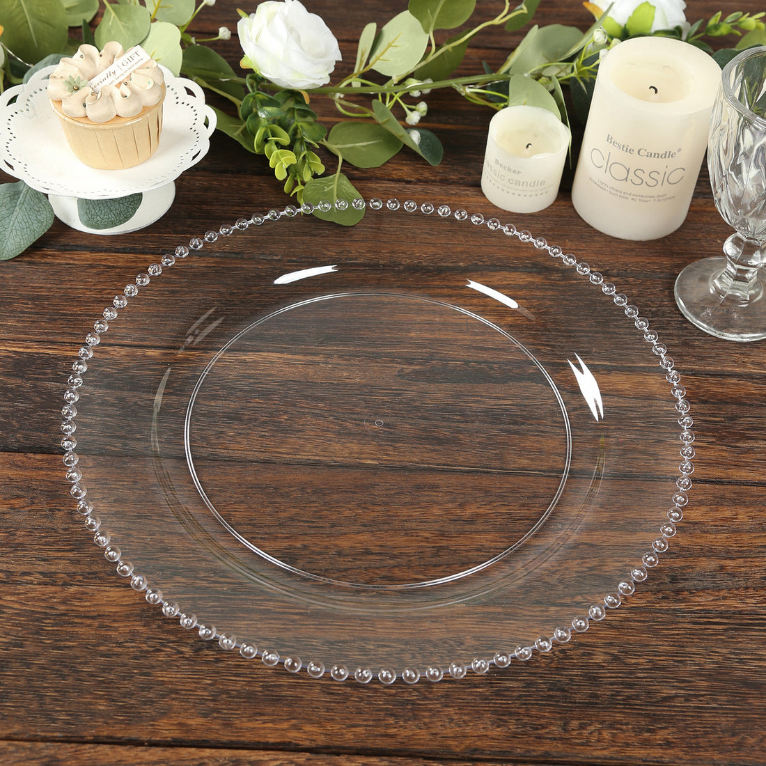Elegant clear glass plate with beaded rim on rustic wooden table.