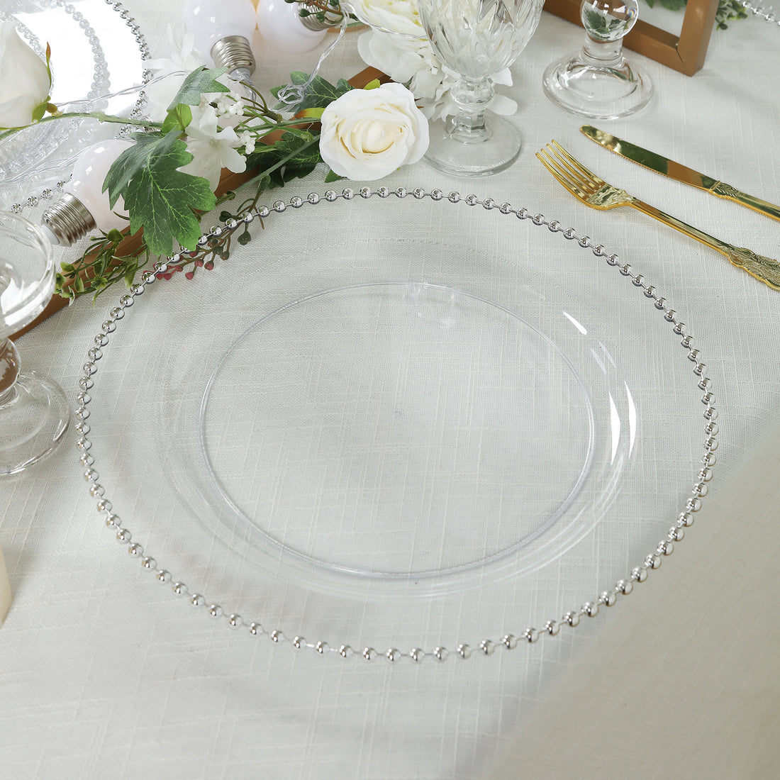 Clear charger plate with beaded rim on elegant table setting.