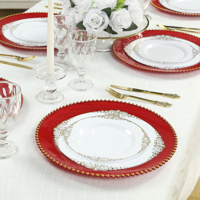 Elegant red and gold decorative plates set on a dining table.