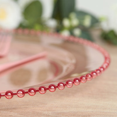 Transparent pink plate with decorative beaded edge.