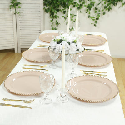 Elegant pink dinner plates set on a beautifully arranged table with floral accents.