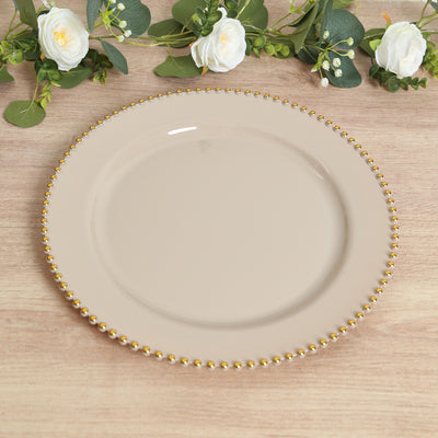 Beaded edge beige dinner plate on a wooden surface with floral accents.
