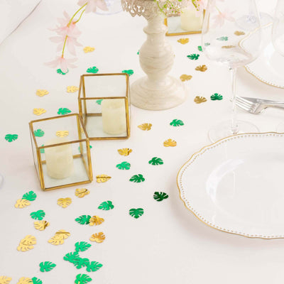 Decorative table setting with candles and leaf confetti for an elegant event.