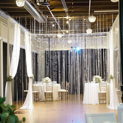 Elegant wedding decor with hanging lights and tables set for an event.
