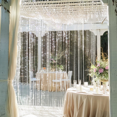Elegant wedding decor with shimmering lights and floral arrangements.