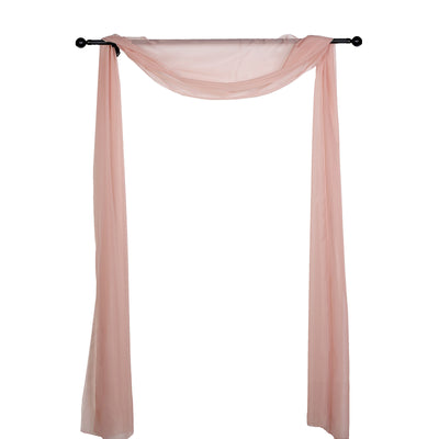 Pink sheer fabric draped on a black curtain rod for elegant decor.