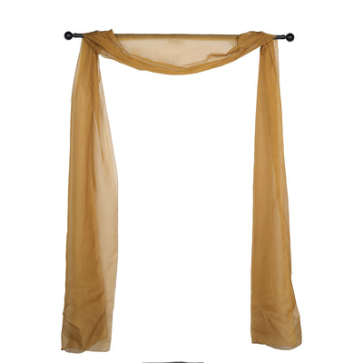 Sheer gold fabric draped elegantly on a black curtain rod