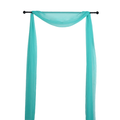 Turquoise sheer fabric draped on a black curtain rod.