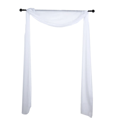 White fabric drapery on a black curtain rod against a plain background
