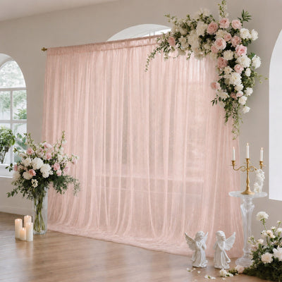 Pastel pink wedding backdrop with floral arrangements and candles