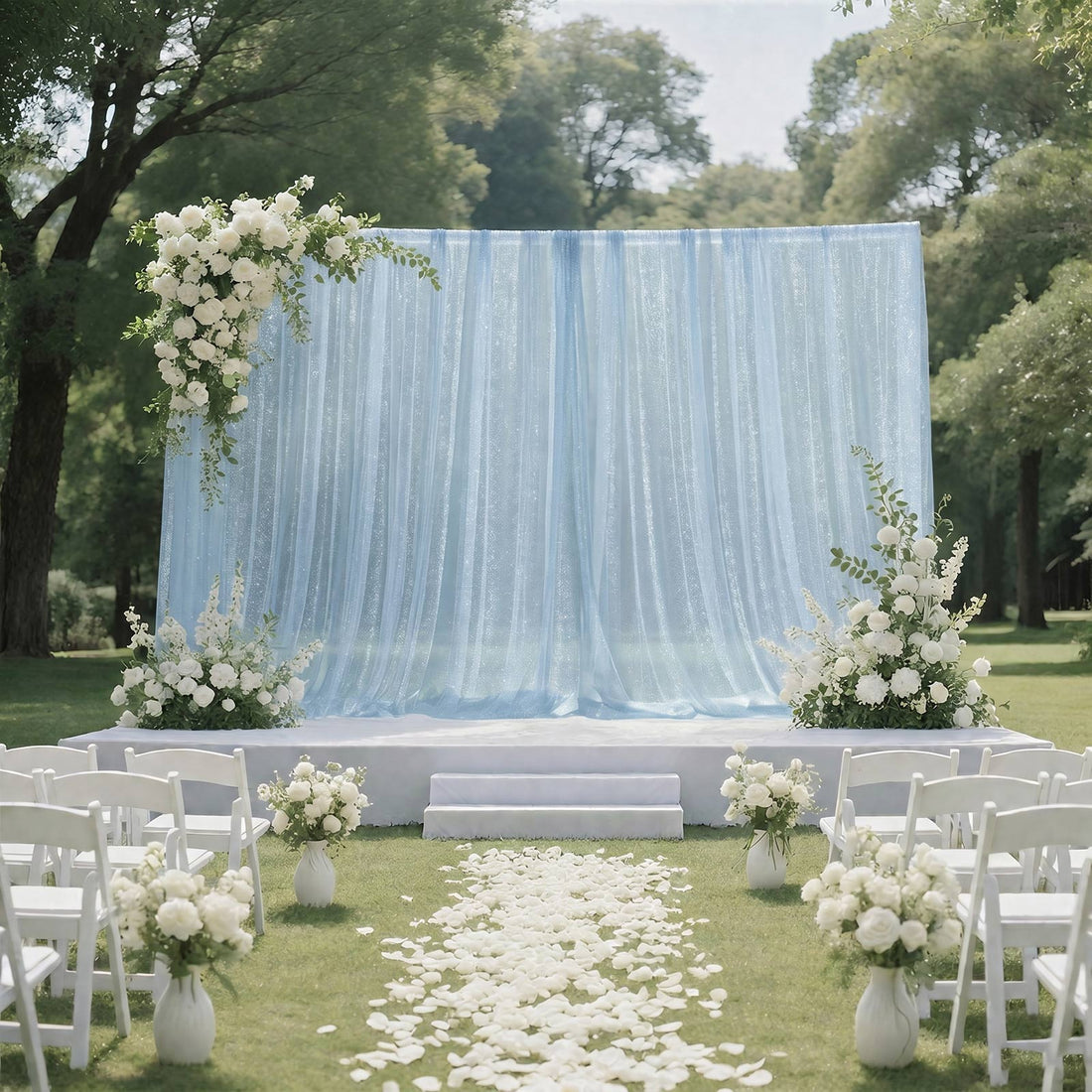 Elegant outdoor wedding ceremony setup with blue backdrop and white floral decor
