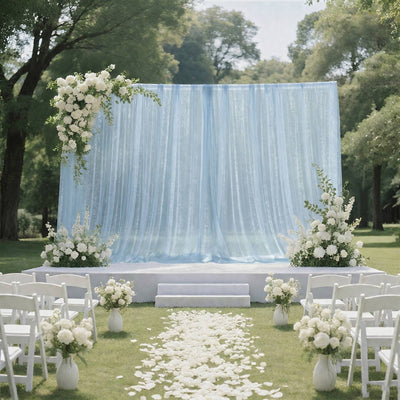 Elegant outdoor wedding ceremony setup with blue backdrop and white floral decor