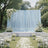 Elegant outdoor wedding ceremony setup with blue backdrop and white floral decor
